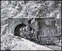 A coal engine steaming through a tunnel